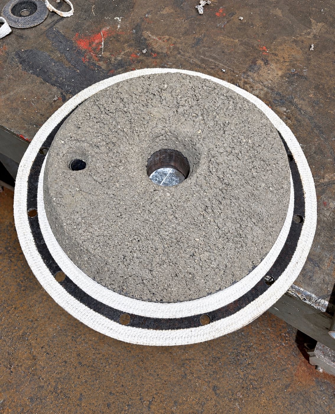 Refractory-lined circular boiler component lying flat in a workshop.