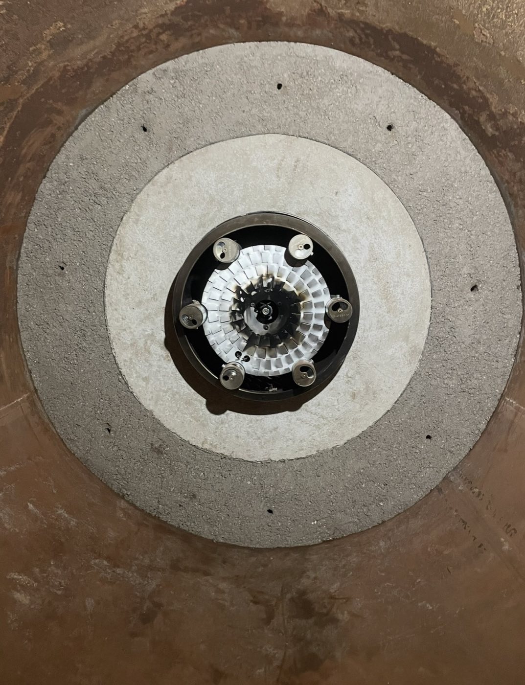 Refractory lining around a burner head inside a boiler.